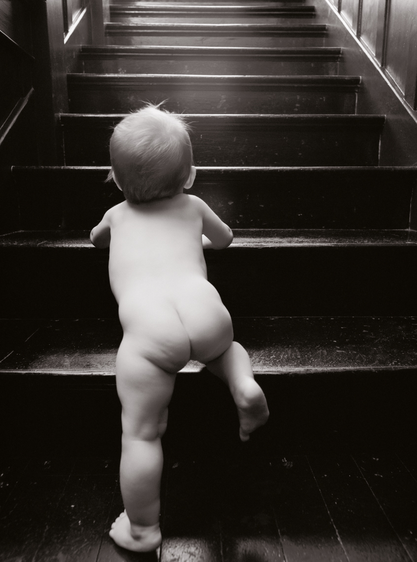 Baby (9-12 months) climbing stairs, rear view (black and white)
