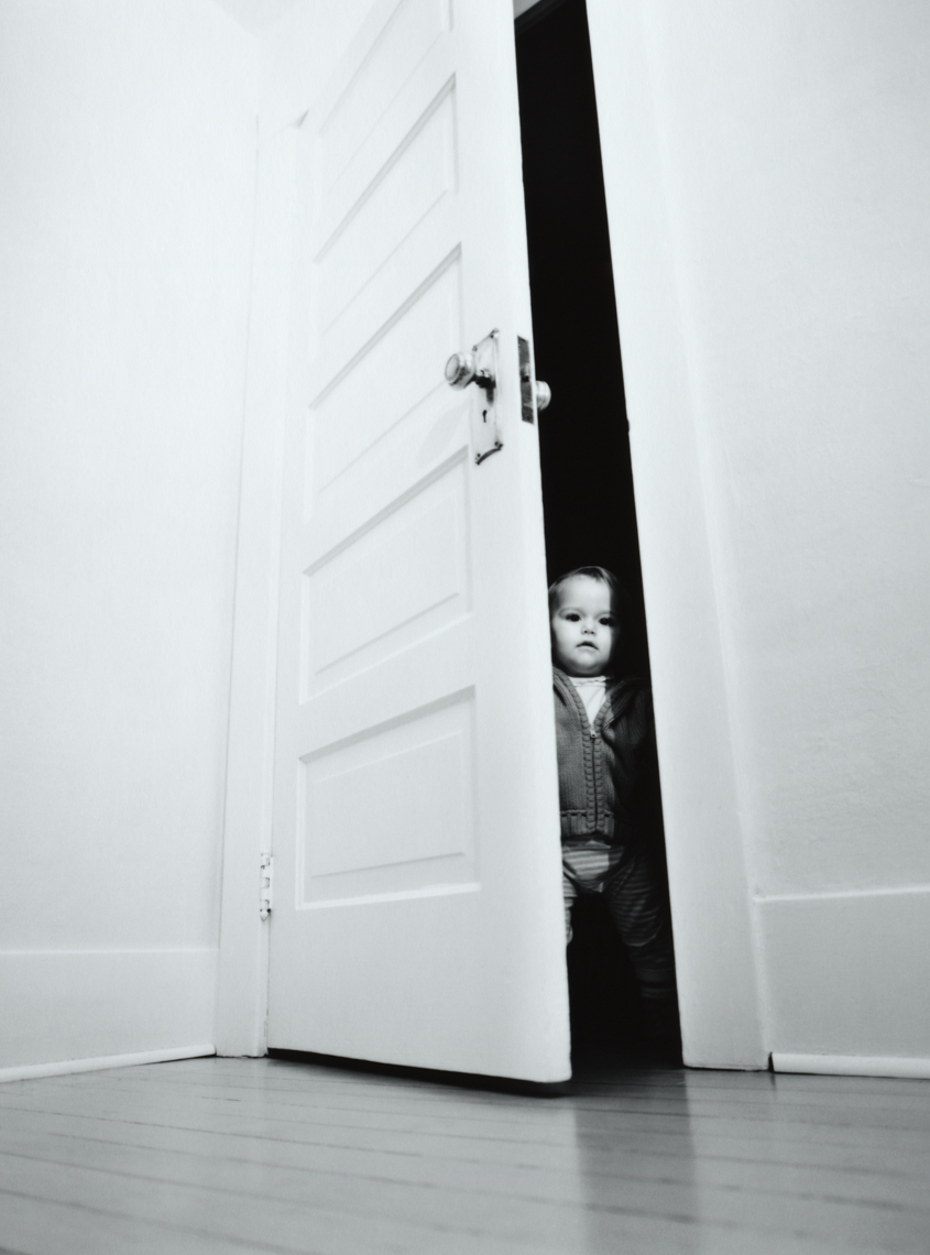Toddler opens a door (black and white).