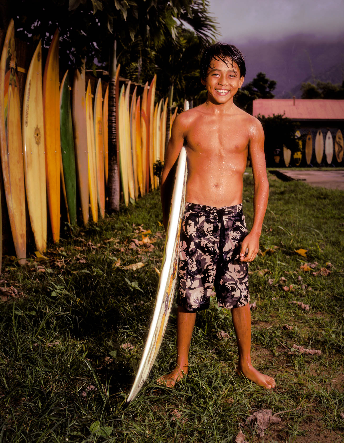 Young boy (12-16 years old) with surfboard in Hanalei, Kauai, HI.